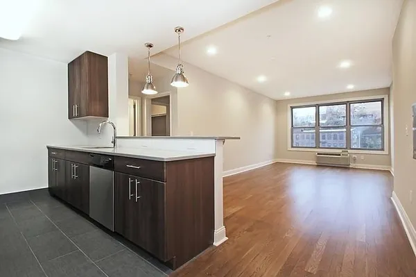 a kitchen with stainless steel appliances granite countertop a sink a stove and a wooden floors