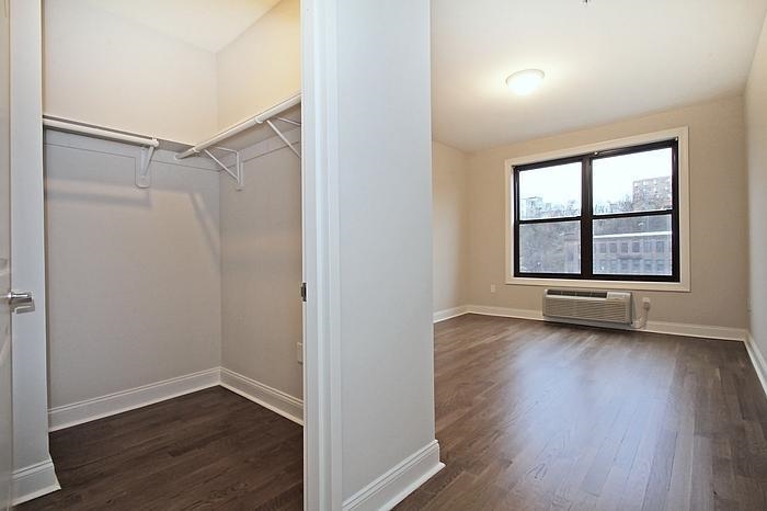100 Marshall Street, Unit 508 Hoboken, NJ 07030 - Photo 5 of 9 an empty room with wooden floor cabinet and windows