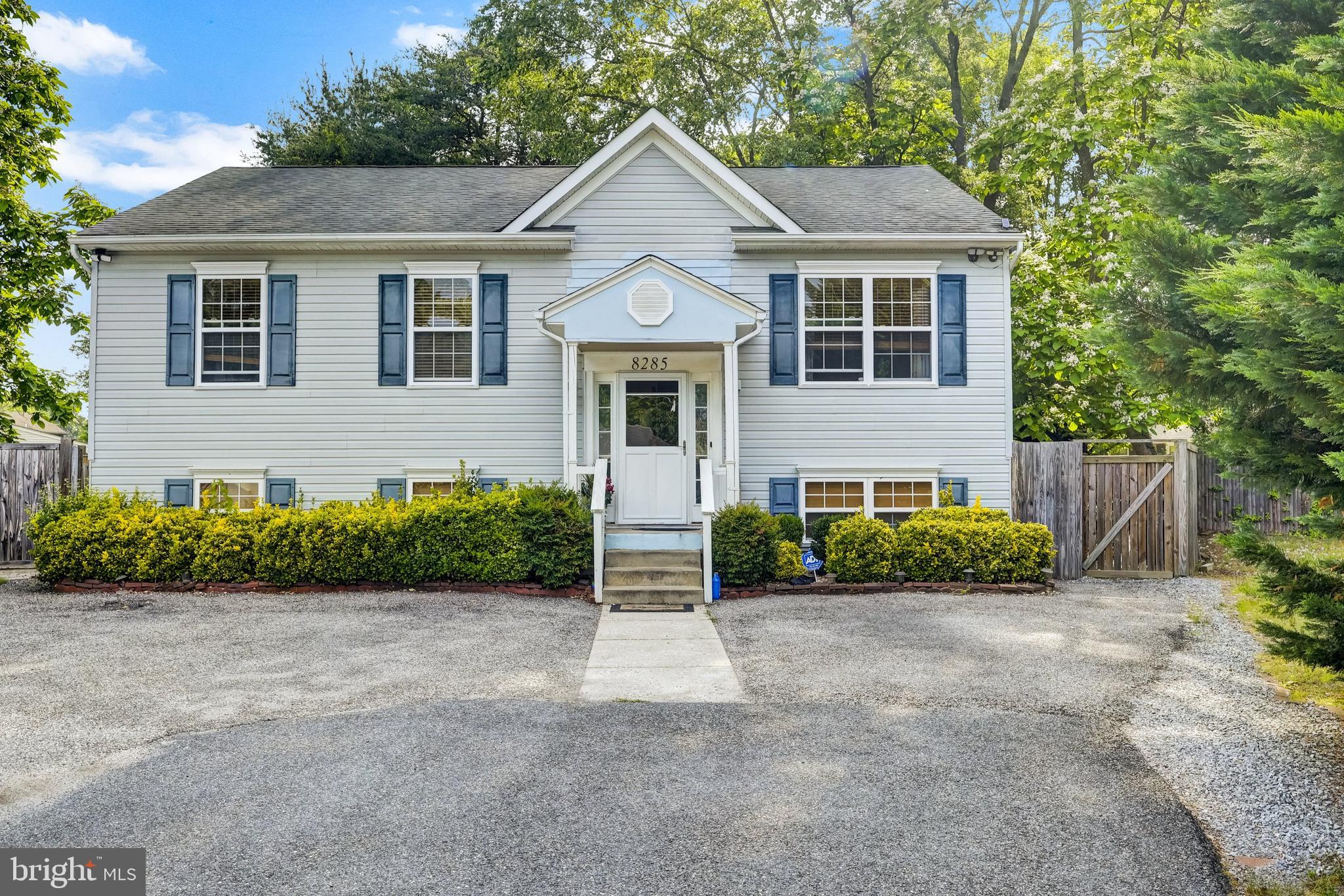 a front view of a house with a garden and plants