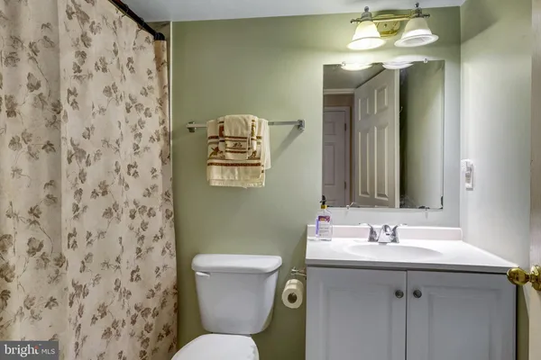 a bathroom with a sink toilet and a mirror