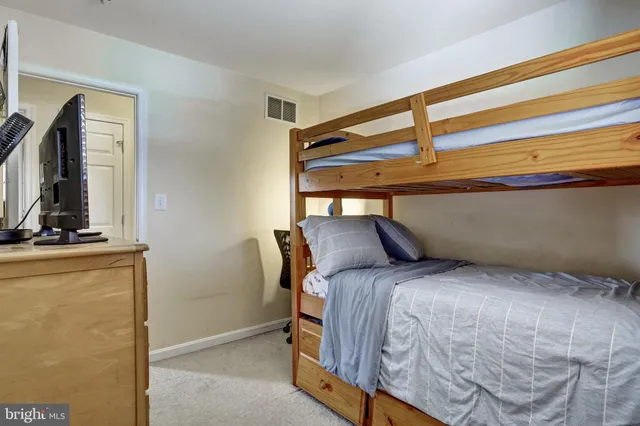 a bedroom with a bed and a flat tv screen on the dresser