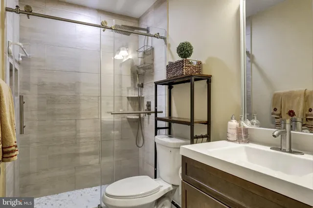 a bathroom with a sink a toilet and shower