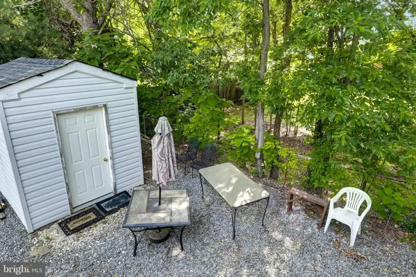 a view of a backyard with table and chairs and a barbeque