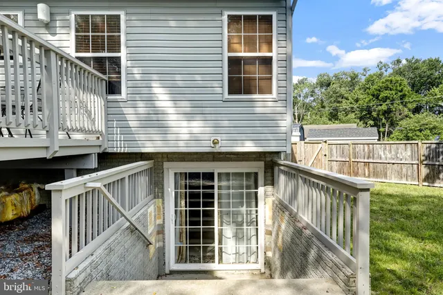 a view of a house with a small yard and wooden floor and fence