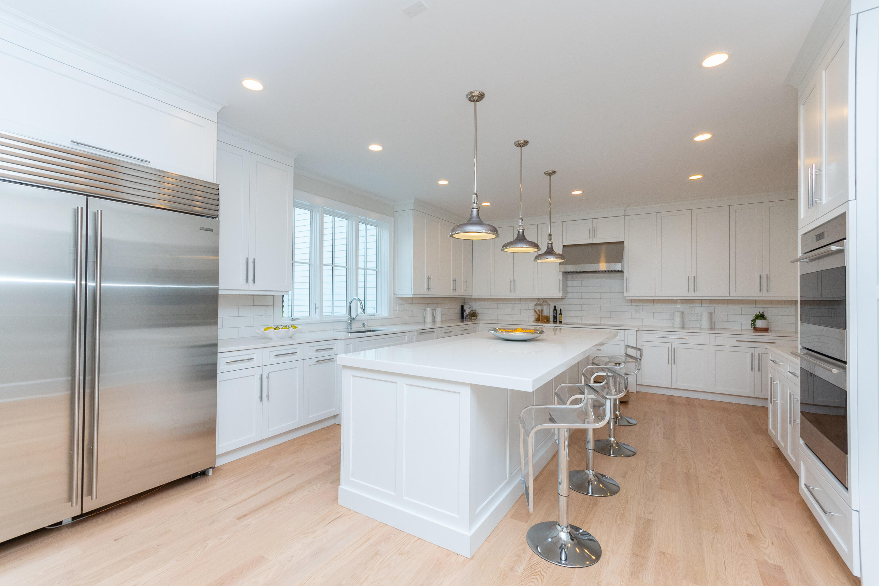 188 Brushy Ridge Road New Canaan, CT 06840 - Photo 15 of 32 a kitchen with kitchen island a stove a sink a refrigerator and chairs