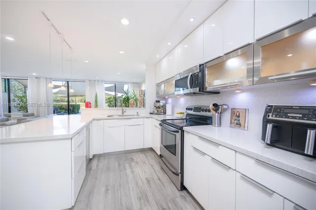 a kitchen with stainless steel appliances sink stove microwave and cabinets