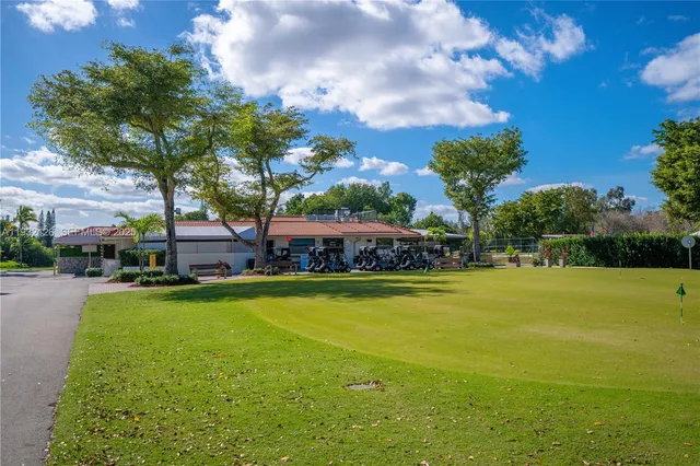 a view of a swimming pool with lawn chairs under an umbrella