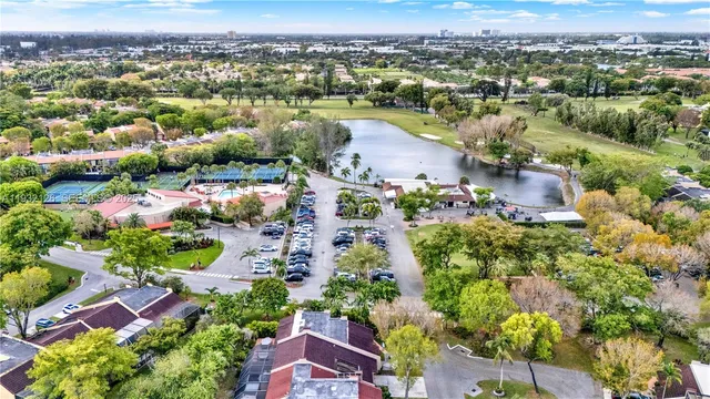 an aerial view of city and lake with trees