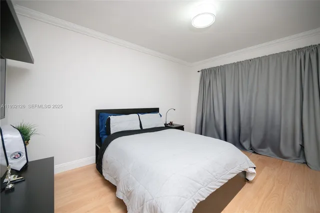 a large bed sitting in a bedroom next to a window