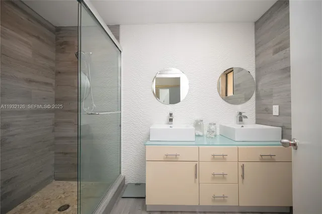 a bathroom with a double vanity sink mirror and shower