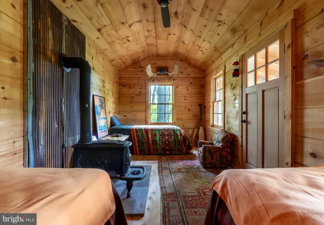 a bedroom with a bed a couch and dresser next to a window