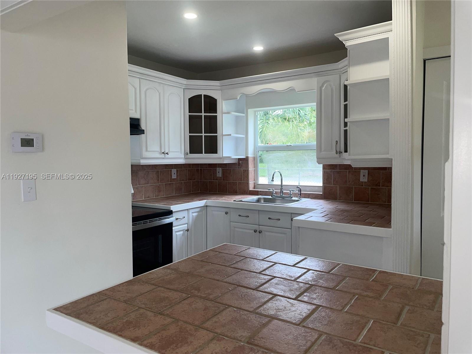 13017 Southwest 18th Terrace, Unit 13017 Miami, FL 33175 - Photo 6 of 21 a kitchen with stainless steel appliances granite countertop a stove a sink and a microwave