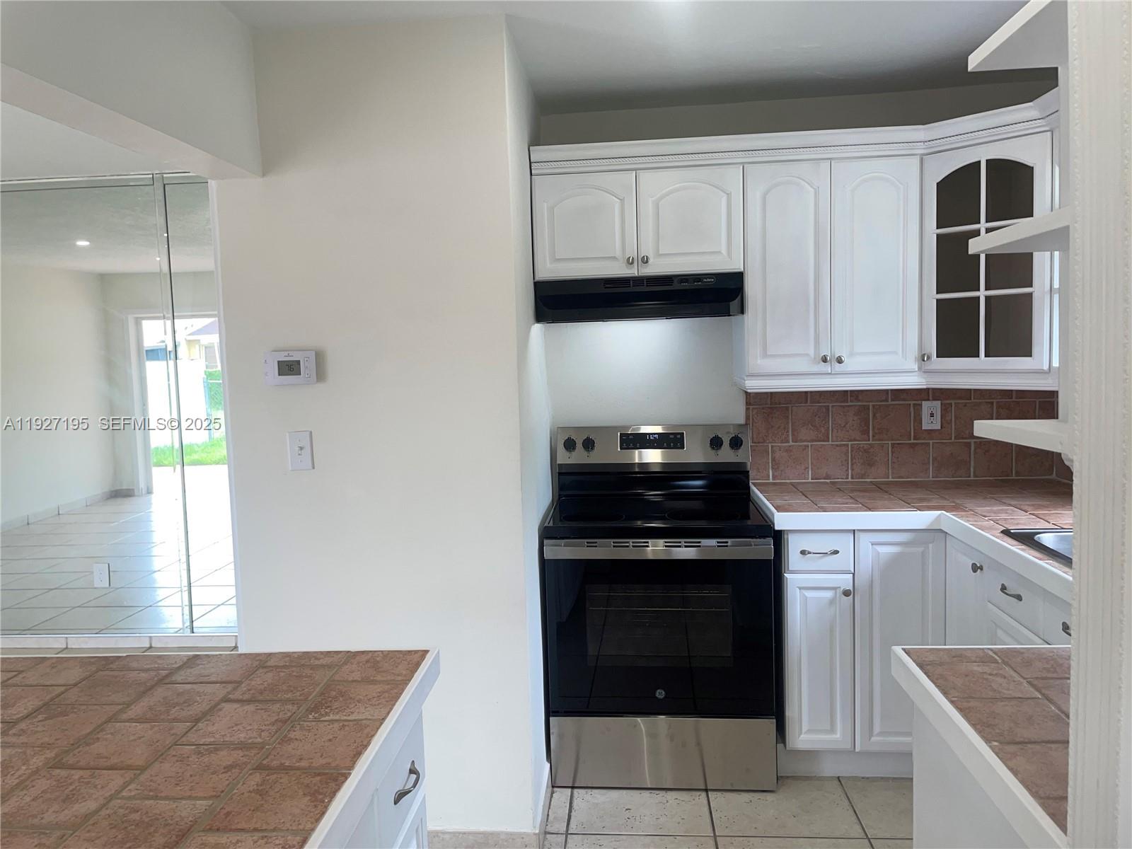 13017 Southwest 18th Terrace, Unit 13017 Miami, FL 33175 - Photo 7 of 21 a kitchen with cabinets appliances and a window