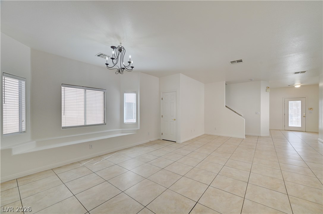 8918 Houston Ridge Avenue Las Vegas, NV 89178 - Photo 3 of 35 A striking chandelier illuminates this spacious, well-lit living area featuring durable tile flooring.