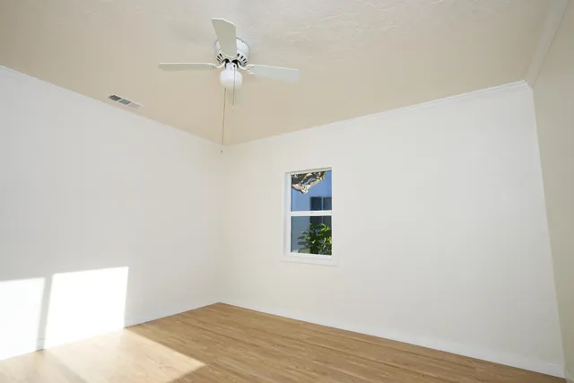 a view of a room with a window and wooden floor