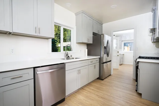 a kitchen with a sink cabinets stainless steel appliances and a window