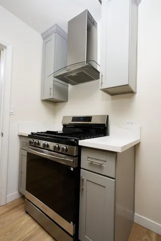 a stove top oven sitting inside of a kitchen