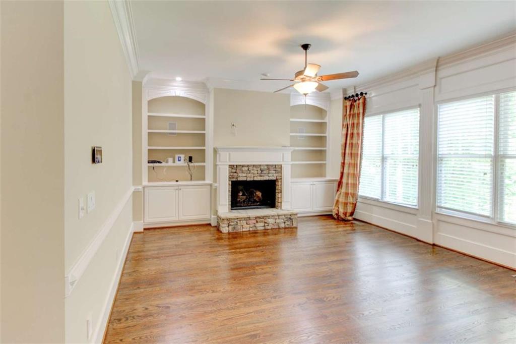 7520 Ledgewood Way Suwanee, GA 30024 - Photo 13 of 95 an empty room with wooden floor fireplace and windows