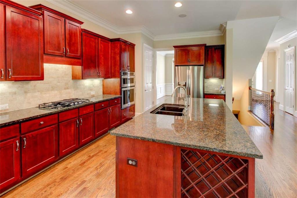 7520 Ledgewood Way Suwanee, GA 30024 - Photo 18 of 95 a kitchen with stainless steel appliances granite countertop a sink dishwasher stove and wooden cabinets