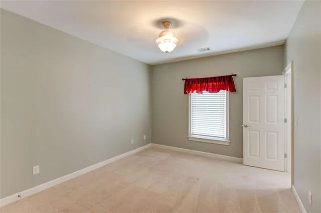 a view of a house with a yard plants and large tree