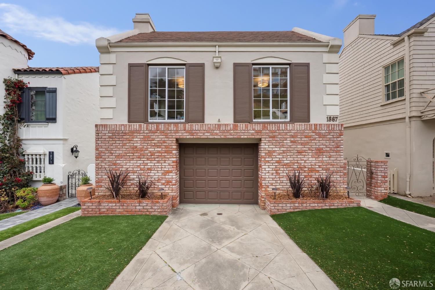 a front view of a house with a garden and plants