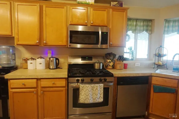 a kitchen with stainless steel appliances granite countertop a sink stove and microwave