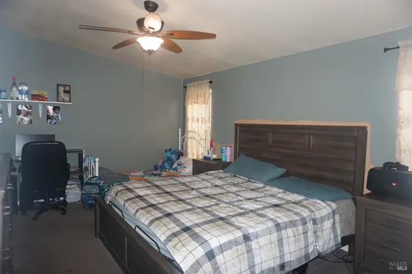 a bedroom with a bed and a chair with the potted plant