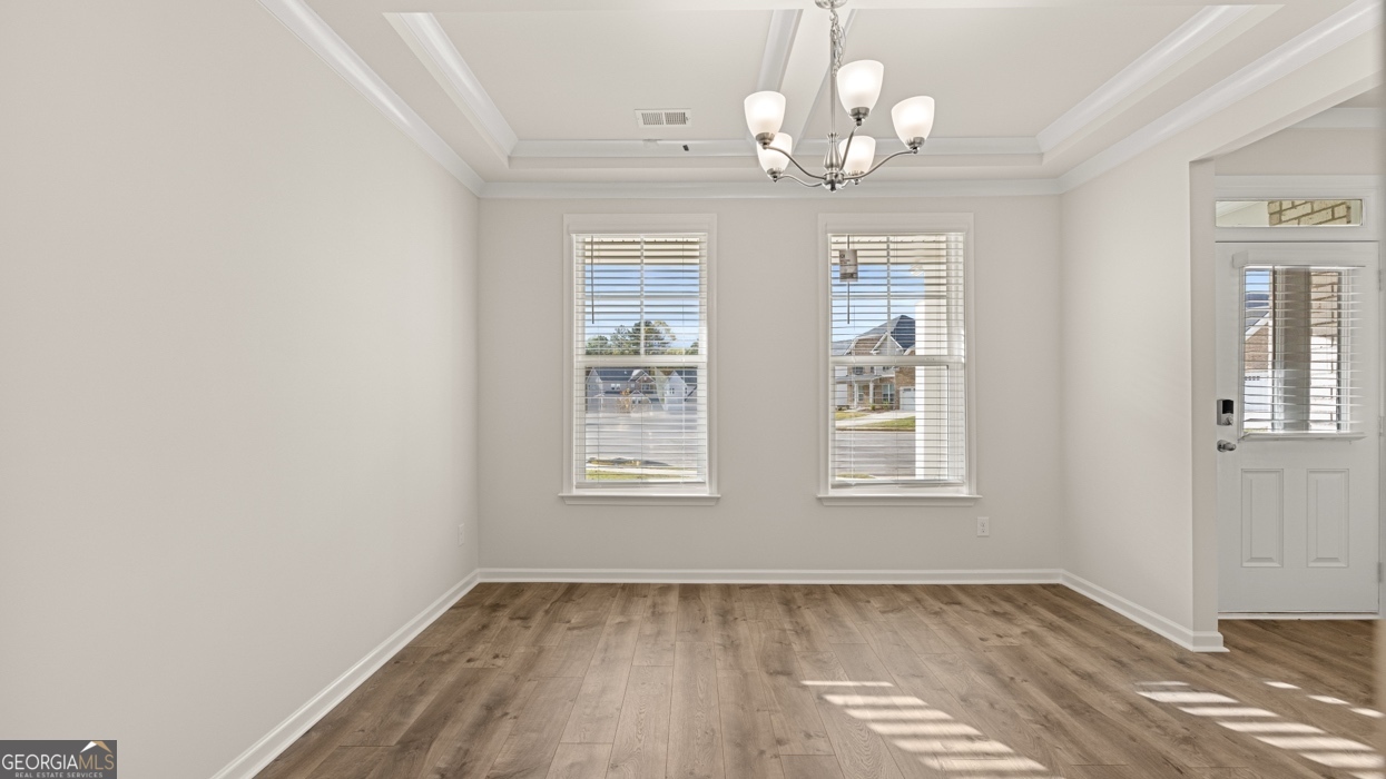 1816 Quaker Street Hampton, GA 30228 - Photo 3 of 32 an empty room with wooden floor chandelier and windows