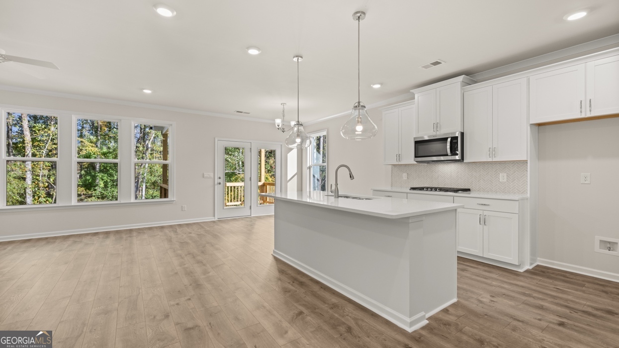 1816 Quaker Street Hampton, GA 30228 - Photo 4 of 32 a large kitchen with kitchen island white cabinets and wooden floors