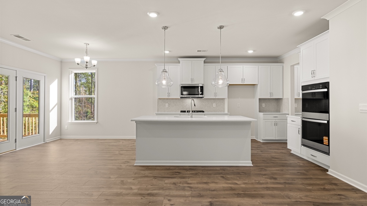 1816 Quaker Street Hampton, GA 30228 - Photo 5 of 32 a large white kitchen with kitchen island a sink white cabinets and stainless steel appliances