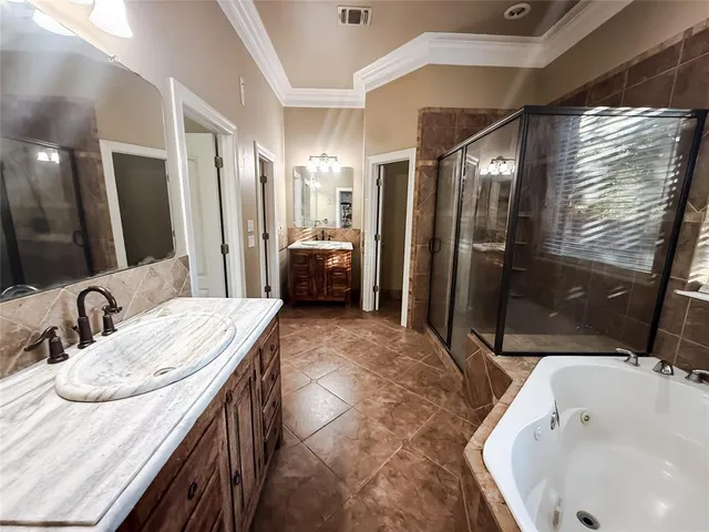 a bathroom with a granite countertop sink a mirror and shower