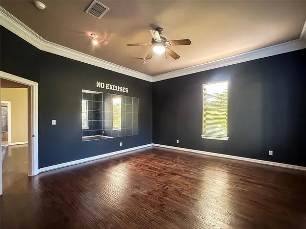 a view of an empty room with window and wooden floor