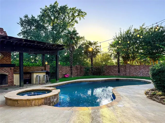 a backyard of a house with fountain table and chairs potted plants and large tree