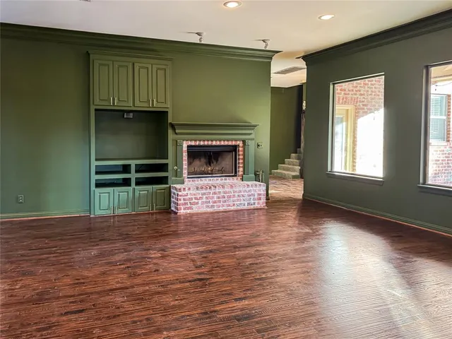 a view of empty room with wooden floor and fireplace