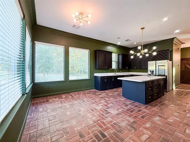 a large kitchen with a refrigerator and a sink