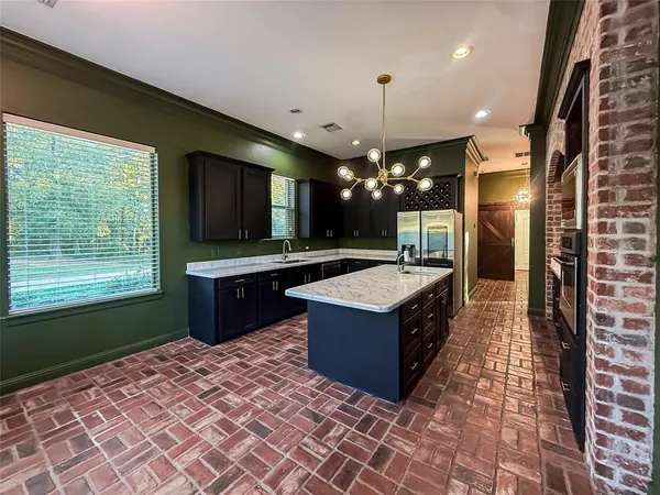 a large kitchen with kitchen island a sink stainless steel appliances and cabinets