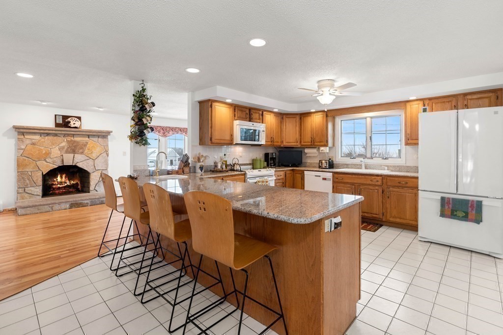 56 Skytop Road Ipswich, MA 01938 - Photo 22 of 42 a kitchen with stainless steel appliances granite countertop a stove top oven a sink dishwasher and a refrigerator with wooden floor