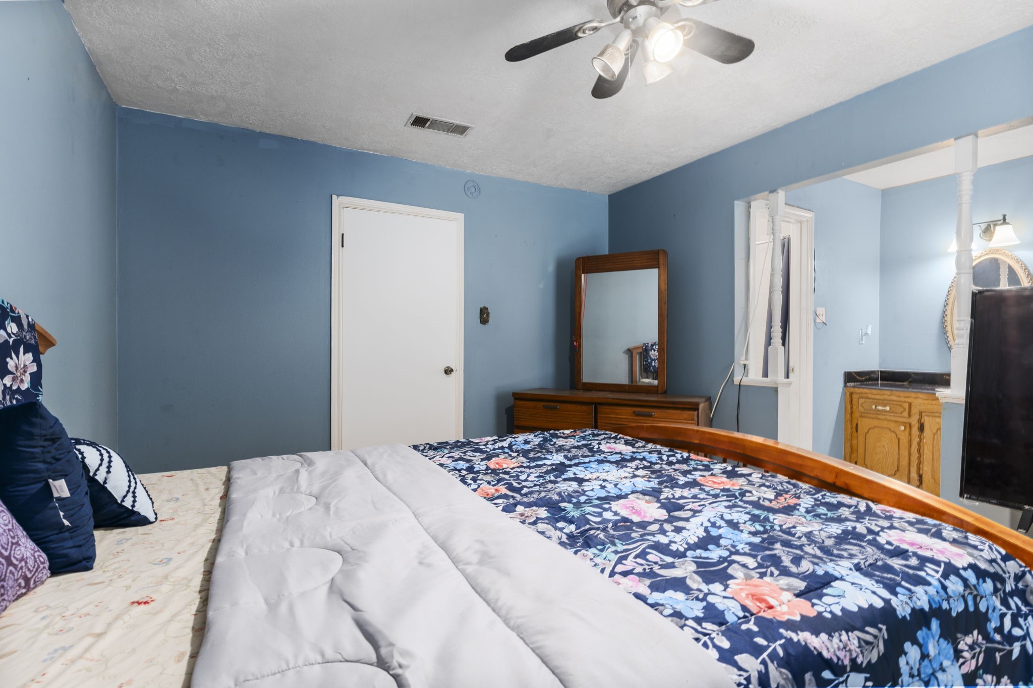 2395 Southline Road Conroe, TX 77384 - Photo 15 of 44 a bedroom with a large bed and a chandelier