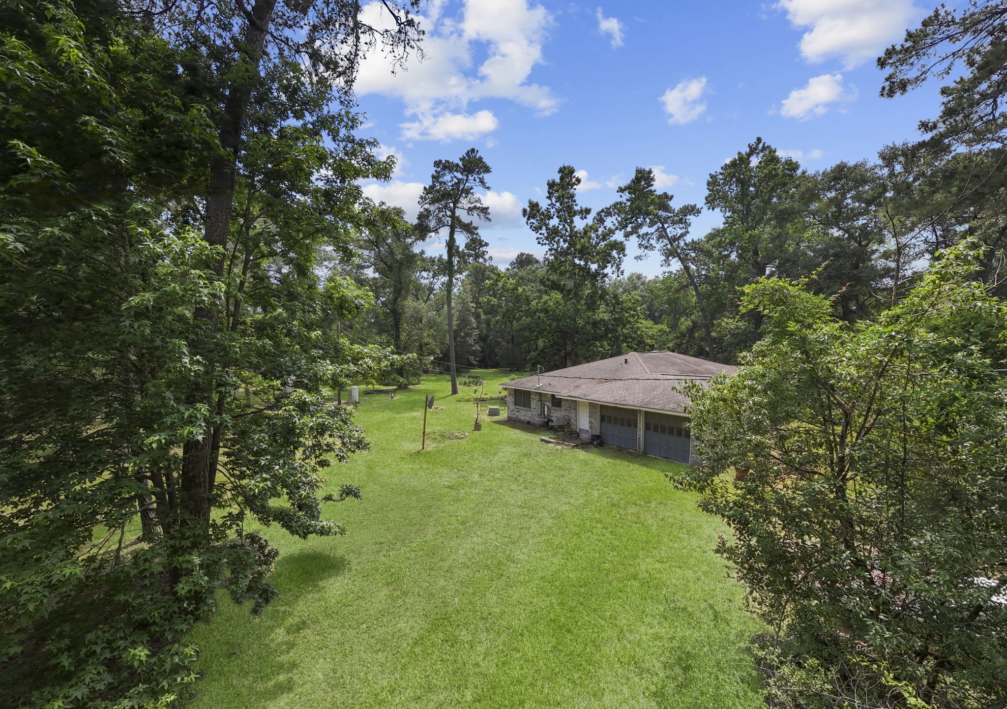 2395 Southline Road Conroe, TX 77384 - Photo 27 of 44 a view of a garden with a table and chairs under an umbrella