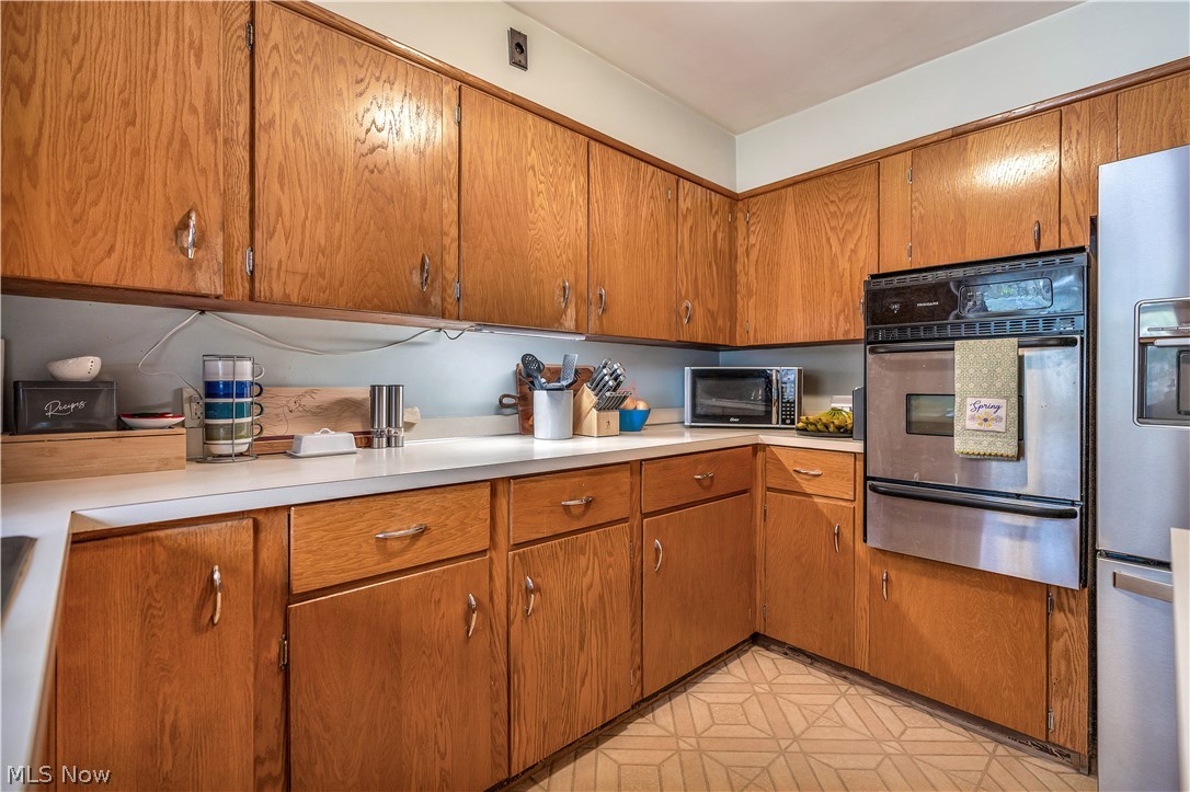 6775 Grove Road Clinton, OH 44216 - Photo 13 of 19 Kitchen with wood finish cabinetry, light countertops, stainless steel appliances, and a warming drawer