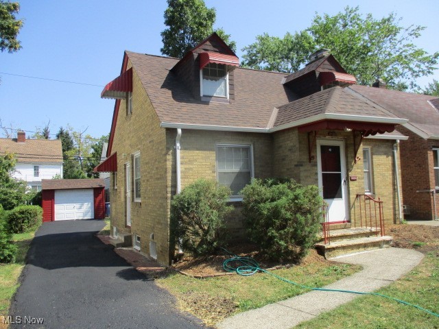 3703 Bainbridge Road Cleveland Heights, OH 44118 - Photo 3 of 16 View of front of house featuring an outdoor structure, brick siding, roof with shingles, and a detached garage