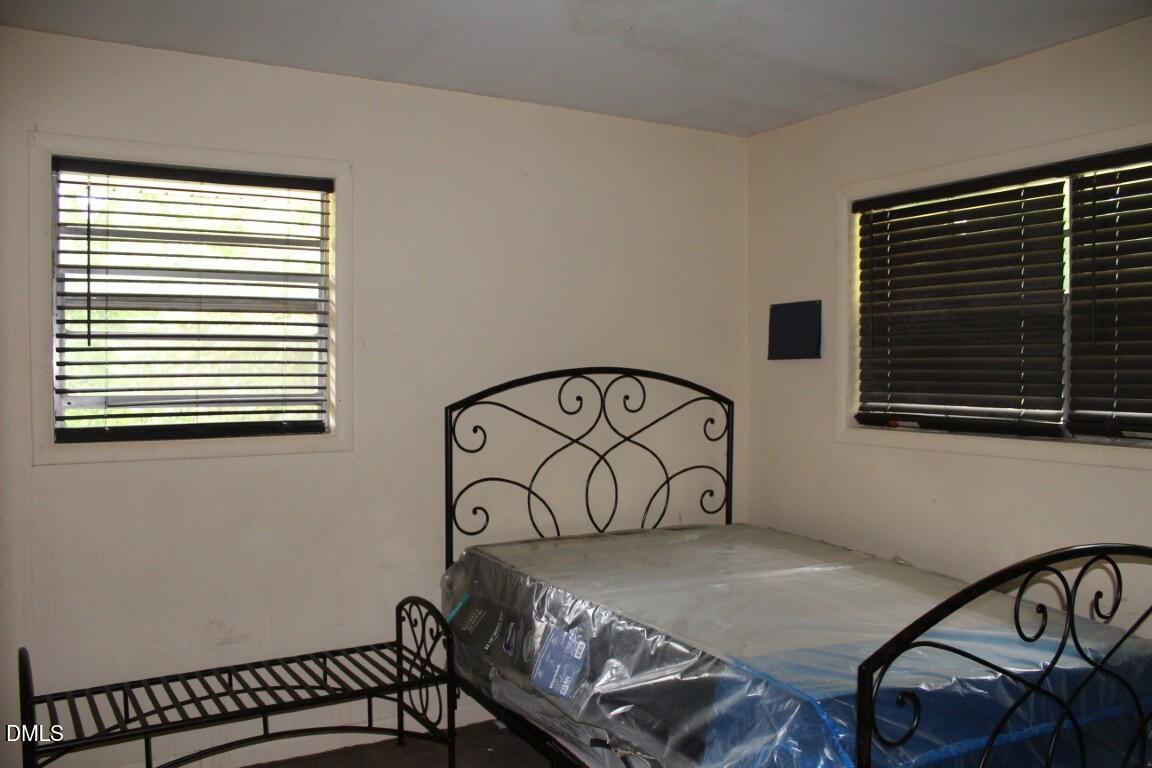 5109 Kaplan Drive Raleigh, NC 27606 - Photo 7 of 13 a bedroom with a bed a table and a window