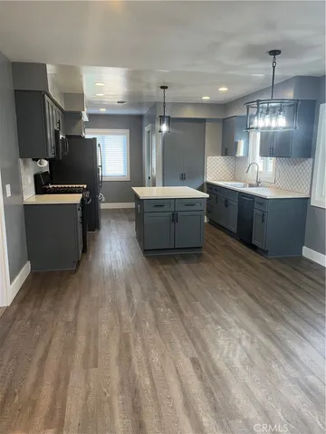 a large kitchen with a lot of counter space and a wooden floor