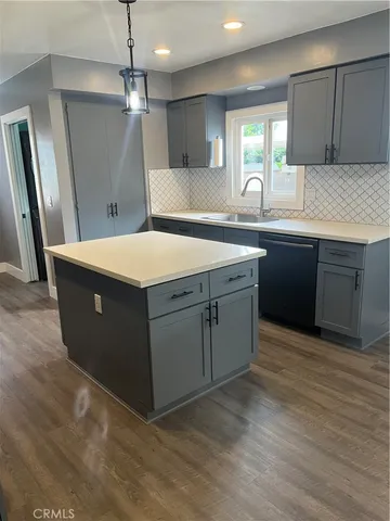 a kitchen with kitchen island a sink a stove a refrigerator and a oven