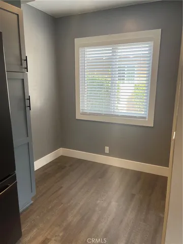 an empty room with wooden floor and a window