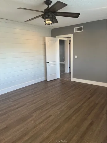 a view of empty room with wooden floor and fireplace