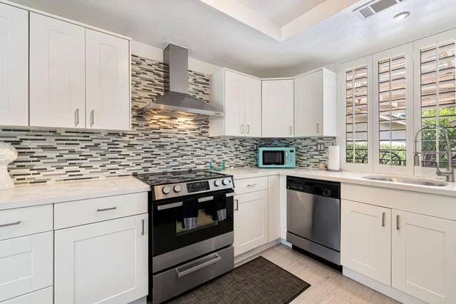 a kitchen with cabinets appliances and a sink