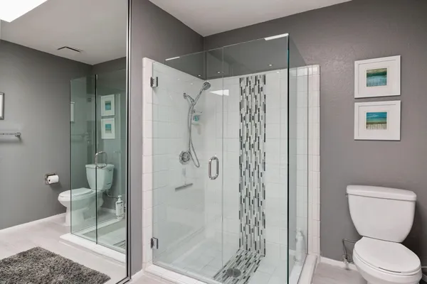 a bathroom with a shower a toilet and a sink