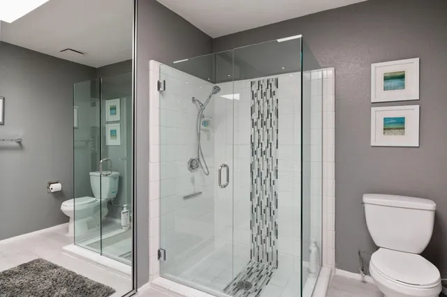 a bathroom with a shower a toilet and a sink