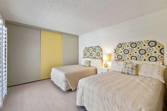 a bedroom with two beds and a night stand